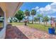 Charming home featuring a brick patio, vibrant plants, and a beautifully maintained lawn with palm trees at 248 Venice East Blvd, Venice, FL 34293