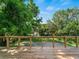 Backyard view from the wooden deck with a wooden fence with wire and beautiful greenery at 3405 10Th W St, Palmetto, FL 34221