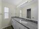Well-lit bathroom with double sinks, granite countertop, and a large mirror with modern lighting at 3405 10Th W St, Palmetto, FL 34221