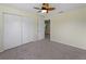 Clean, carpeted bedroom features a ceiling fan, closet, and a doorway into another room at 3405 10Th W St, Palmetto, FL 34221