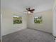 Neutral bedroom with carpeting, lighted ceiling fan, two windows with an outdoor view, and closet at 3405 10Th W St, Palmetto, FL 34221