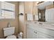Bathroom featuring a toilet, vanity with sink, mirror, and natural colored walls at 436 Canal Rd # A, Sarasota, FL 34242