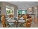 Open-concept dining area with a glass table, wicker chairs, and view into the living area and the 'Beach' sign at 436 Canal Rd # A, Sarasota, FL 34242