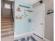 Entryway featuring tiled flooring, staircase, decorative beach accents, and a convenient coat rack at 436 Canal Rd # A, Sarasota, FL 34242