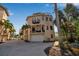 Beige three-story home featuring multiple balconies and a rooftop deck, surrounded by lush palm trees at 436 Canal Rd # A, Sarasota, FL 34242