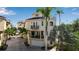 Beige three-story home featuring multiple balconies and a rooftop deck, surrounded by lush palm trees at 436 Canal Rd # A, Sarasota, FL 34242