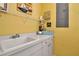 Bright laundry room with a utility sink, white cabinets, and a decorative sailboat wall hanging at 436 Canal Rd # A, Sarasota, FL 34242