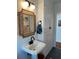 Bathroom features a pedestal sink, stylish mirror and ample storage in a linen closet at 4704 Winchester Dr, Sarasota, FL 34234