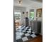 Hallway displaying checkerboard floors and two grey cabinets, lit by natural light from a large window at 4704 Winchester Dr, Sarasota, FL 34234
