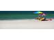 Expansive beach view showcasing pristine sand and turquoise water near beachgoers and colorful umbrellas at 4861 Waterbridge Down, Sarasota, FL 34235