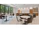 Comfortable clubhouse seating area with tables, chairs, a large window, and counter space with storage cabinets at 4861 Waterbridge Down, Sarasota, FL 34235