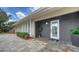 Modern home entrance showcasing a textured gray exterior, white door, and tidy landscaping at 4861 Waterbridge Down, Sarasota, FL 34235