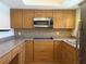 Kitchen featuring wooden cabinets, tile backsplash, and modern appliances at 5057 Live Oak Cir # 86, Bradenton, FL 34207