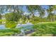 Serene view of a community pond with lush greenery, a bench, and scenic reflections at 5057 Live Oak Cir # 86, Bradenton, FL 34207
