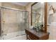 Bright bathroom with tiled walls and a glass-enclosed bathtub with a vanity station and updated lighting at 5403 Red Rooster Rd, Parrish, FL 34219