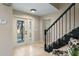Inviting foyer with black staircase, white front door, and tile flooring that creates a welcoming entrance at 5403 Red Rooster Rd, Parrish, FL 34219