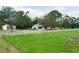 Sprawling home exterior featuring a white fence, large trees, and a detached garage at 5403 Red Rooster Rd, Parrish, FL 34219