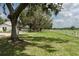 Spacious front yard with a white fence, mature trees, and lush green grass at 5403 Red Rooster Rd, Parrish, FL 34219