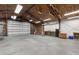 Spacious garage with an insulated ceiling, concrete floor, and a large roll-up door at 5403 Red Rooster Rd, Parrish, FL 34219