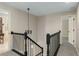 Hallway featuring black staircase railings and carpet flooring, blending functionality with a touch of elegance at 5403 Red Rooster Rd, Parrish, FL 34219