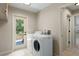 Convenient laundry room with modern washer and dryer, tile flooring, and direct access to the outdoors at 5403 Red Rooster Rd, Parrish, FL 34219