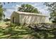 Exterior view of an outbuilding with siding and metal roof situated on a grassy lot at 5403 Red Rooster Rd, Parrish, FL 34219