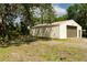 Outbuilding on a sunny lot has a garage door and a standard door at 5403 Red Rooster Rd, Parrish, FL 34219