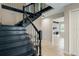 Elegant staircase with black railings and tile flooring, providing a grand transition between floors at 5403 Red Rooster Rd, Parrish, FL 34219