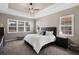 This bedroom features a tray ceiling, ceiling fan, carpet floors, and multiple windows providing ample natural light at 569 Mast Dr, Bradenton, FL 34208