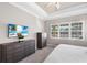Serene bedroom featuring plush carpet, tray ceiling, and a large window providing natural light at 569 Mast Dr, Bradenton, FL 34208
