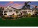 Beautifully landscaped home featuring a manicured lawn, lush greenery, and a charming walkway leading to the entrance at 569 Mast Dr, Bradenton, FL 34208