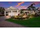Charming single-story home with a well-manicured lawn, vibrant landscaping, and a three-car garage at 569 Mast Dr, Bradenton, FL 34208