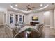 Bright living room with modern furnishings, a tray ceiling, and access to an outdoor pool area at 569 Mast Dr, Bradenton, FL 34208