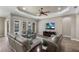 Relax in this living room with tray ceilings, a ceiling fan and views of the backyard oasis at 569 Mast Dr, Bradenton, FL 34208