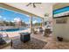 Spacious outdoor living area with pool, ceiling fans, grill, and comfortable seating for outdoor dining and entertainment at 569 Mast Dr, Bradenton, FL 34208