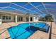 Outdoor pool with attached spa featuring a screen enclosure and spacious patio area at 569 Mast Dr, Bradenton, FL 34208