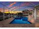 Beautiful screened pool and spa with brick paver deck, overlooking the water and outdoor kitchen at 569 Mast Dr, Bradenton, FL 34208
