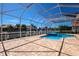 Screened-in pool and patio area featuring brick pavers and waterfront views of the canal at 569 Mast Dr, Bradenton, FL 34208