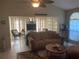 Bright living room featuring tile floors, comfortable seating, an adjacent sunroom, and neutral tones at 5712 34Th W Ct, Bradenton, FL 34210