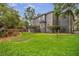 Home exterior featuring a landscaped backyard, patio, and lush green lawn at 5716 Bayshore Blvd, Tampa, FL 33611