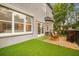 Backyard patio with artificial turf, metal fence, outdoor seating, and fire pit at 5716 Bayshore Blvd, Tampa, FL 33611