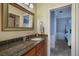 Bathroom featuring a vanity with a granite top and decorative mirror and convenient access to the bedroom at 5716 Bayshore Blvd, Tampa, FL 33611