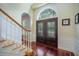 Elegant foyer featuring hardwood floors, a grand staircase, and a beautiful arched window above the front door at 5716 Bayshore Blvd, Tampa, FL 33611