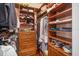Walk-in closet featuring custom wood shelving and ample storage space for organization at 5716 Bayshore Blvd, Tampa, FL 33611