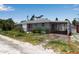 Single-story home featuring a covered carport with a small flower garden at 7030 Lois Ave, Longboat Key, FL 34228