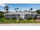 Charming single-story home featuring a clean design, gray siding, and vibrant landscaping with tropical foliage at 7030 Lois Ave, Longboat Key, FL 34228
