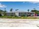 Single-story home featuring colorful flower bushes and green grass at 7030 Lois Ave, Longboat Key, FL 34228