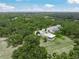 Aerial view of an estate featuring a modern luxury home, with a long driveway and mature trees and landscaping at 7234 Letitia Ln, Sarasota, FL 34241