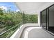 Balcony with metal railing and tile floor overlooks green trees and blue sky at 7234 Letitia Ln, Sarasota, FL 34241