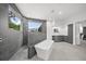 Contemporary bathroom featuring a soaking tub, walk-in shower, and gray cabinetry at 7234 Letitia Ln, Sarasota, FL 34241